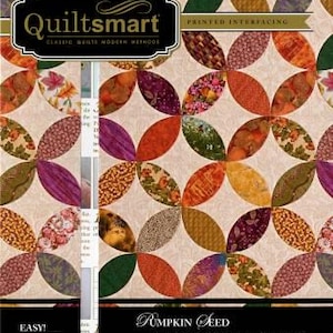 May include: Quiltsmart pattern for a pumpkin seed quilt. The pattern features a white background with a repeating pattern of orange, brown, purple, and green curved shapes. The text "Quiltsmart" and "Pumpkin Seed" are printed on the pattern.