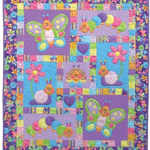 May include: A colourful quilt with a patchwork design featuring butterflies, caterpillars, ladybugs, and snails. The quilt is made with a variety of fabrics in shades of pink, purple, blue, green, and yellow.