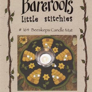 May include: A felt candle mat with a beehive design. The mat is brown and green with yellow flowers and bees. The text "#164 Beeskeeps Candle Mat" is printed on the image.
