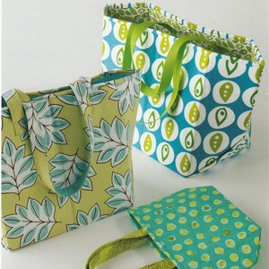 May include: Three fabric tote bags with green and blue patterns. The bags are labeled "Stand 'N Stow" and "Atkinson Designs, one of life's simple pleasures".