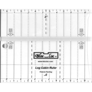 May include: A clear, rectangular Log Cabin Ruler with black markings and the "Bloc Loc" logo. The ruler features measurements in inches, with markings for 2" and 3" seams. The text "Log Cabin Ruler" and "Patents Pending" are also visible.