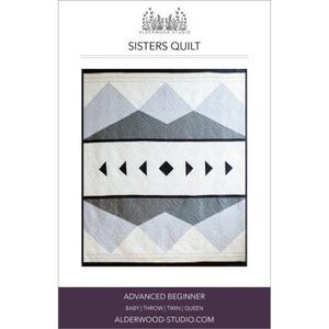 May include: A quilt pattern featuring a geometric design with black and gray triangles and a row of black arrows. The pattern is called "Sisters Quilt" and is for an advanced beginner. The quilt can be made in baby, throw, twin, or queen sizes.