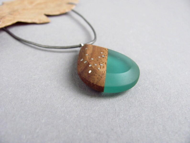 Drop-shaped pendant made of walnut wood and turquoise resin.