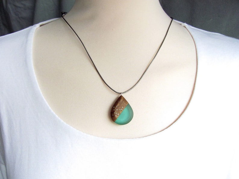 Drop-shaped pendant made of walnut wood and turquoise resin.