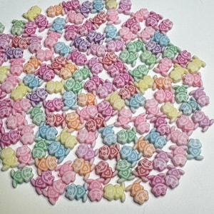 May include: A large group of colorful plastic beads in the shape of a smiling face. The beads are in shades of pink, yellow, green, and blue.