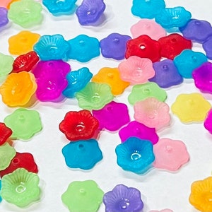 May include: Assortment of colorful flower-shaped plastic beads. The beads are translucent and have a hole in the center for stringing.