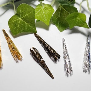 May include: Six ornate metal cone-shaped bead caps in gold, silver, and bronze.
