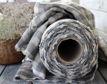 May include: A roll of gray and white checkered linen fabric with frayed edges. The fabric is rolled up on a cardboard tube. The text "Wonder Linen" is visible on the fabric.