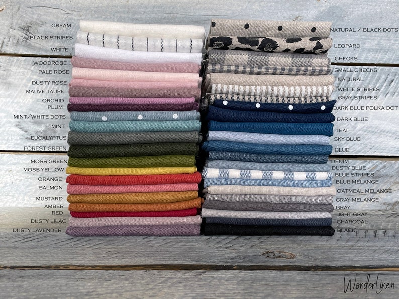 May include: A collection of linen fabric swatches in various colors and patterns, including solid colors, stripes, polka dots, and checks. The swatches are labeled with their names, such as "cream", "black stripes", "white", "woodrose", "pale rose", "dusty rose", "mauve taupe", "orchid", "plum", "mint/white dots", "mint", "eucalyptus", "forest green", "moss green", "moss yellow", "orange", "salmon", "mustard", "amber", "red", "dusty lilac", "dusty lavender", "natural/black dots", "leopard", "checks", "small checks", "natural", "white stripes", "gray stripes", "dark blue polka dot", "dark blue", "teal", "sky blue", "blue", "denim", "dusty blue", "blue stripes", "blue melange", "oatmeal melange", "gray melange", "gray", "light gray", "charcoal", and "black".