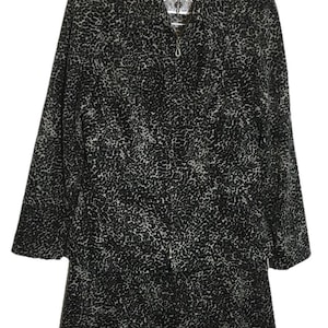 May include: A black and gray patterned jacket with a zipper closure. The jacket has a collar and long sleeves. The pattern is a repeating design of small, irregular shapes. The jacket is hanging on a hanger.