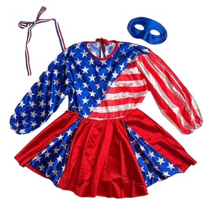 May include: A red, white, and blue satin dress with a star-spangled design. The dress has long sleeves and a gathered skirt. A blue eye mask is included.