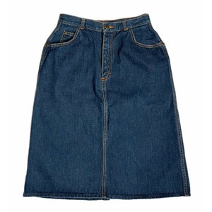 Può includere: Una gonna in denim blu scuro con vita alta e chiusura con bottone. La gonna ha due tasche anteriori e una silhouette dritta.