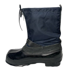 K&ouml;nnte beinhalten: Schwarze Gummistiefel f&uuml;r den Winter mit schwarzem Nylon-Obermaterial und einer Kordelschn&uuml;rung. Die Stiefel haben einen schwarzen Lederriemen &uuml;ber dem Obermaterial.