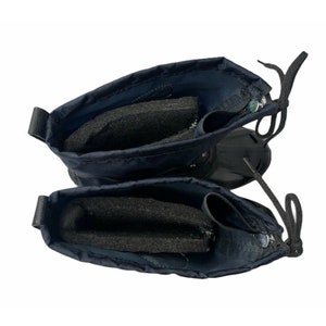 K&ouml;nnte beinhalten: Ein Paar dunkelblaue Winterstiefel mit schwarzem Fleecefutter. Die Stiefel haben einen Rei&szlig;verschluss und Schn&uuml;rsenkel.