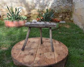 Taburete antiguo de madera de tres patas: decoración primitiva hecha a mano
