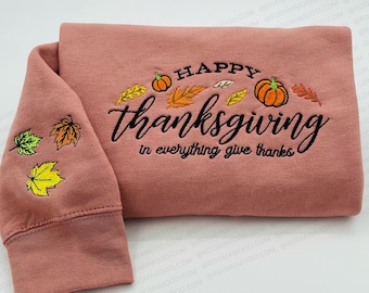 May include: A pink sweatshirt with the text "Happy Thanksgiving in everything give thanks" embroidered in black. The design includes pumpkins and fall leaves.