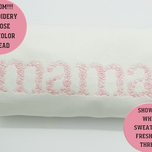 以下が含まれることがあります： 白いスウェットシャツに、ピンクの花柄の文字で「mama」と刺繍されています。画像の上部にはピンクの円の中に「CUSTOM!!!! EMBROIDERY CHOOSE ANY COLOR THREAD」というテキストが書かれています。画像の下部にはピンクの円の中に「SHOWN IN WHITE SWEATSHIRT FRESH PINK THREAD」というテキストが書かれています。