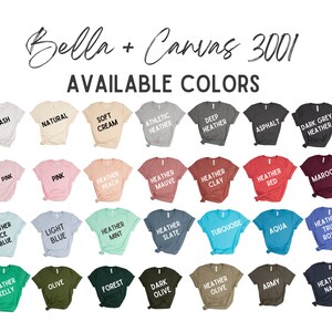 May include: A selection of Bella + Canvas 3001 t-shirts in a variety of colours, including Ash, Natural, Soft Cream, and Athletic Heather. The image displays a wide range of hues, from Soft Pink and Pink to Heather Red and Maroon. The text "AVAILABLE COLORS" is displayed.