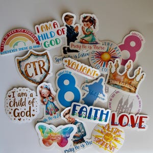 Puede incluir: Una colección de pegatinas coloridas con temas religiosos. Las pegatinas presentan frases como "Soy un hijo de Dios", "Ora, Él está allí" y "Fe". Los diseños incluyen un arcoíris, una corona e ilustraciones de niños rezando.