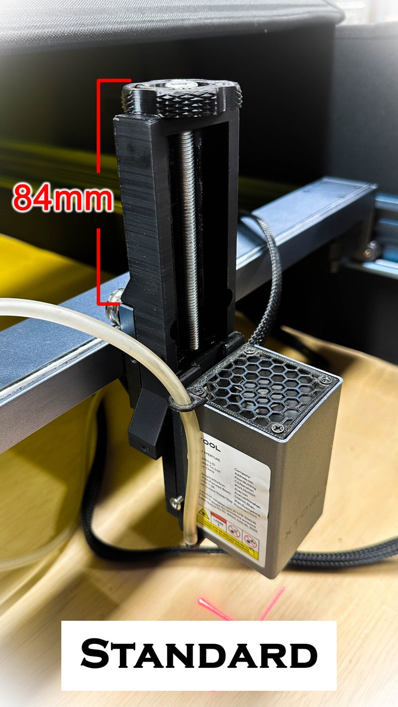 Pu&ograve; includere: Un pezzo nero per stampante 3D con una barra filettata e una ventola di raffreddamento esagonale. Il pezzo &egrave; alto 84 mm ed &egrave; fissato a una barra di metallo argentata. Il pezzo &egrave; etichettato "TOOL".