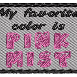 May include: Embroidered patch with the text "My favourite colour is PINK MIST" in black and pink. The patch has a grey background and a black border. The pink text is in a bold, stylized font.
