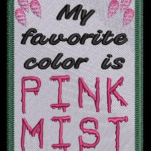 May include: Embroidered patch with the text "My favourite colour is PINK MIST" in black and pink thread. The patch has a light grey background, a green border, and pink decorative elements at the top.