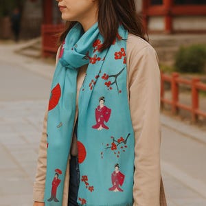 The Geisha Scarf is a lightweight, semi-sheer Aqua blue wrap with a Japanese-inspired Pashmina design