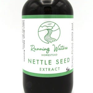 May include: A brown glass bottle with a black dropper top. The label reads "Running Waters Homestead Nettle Seed Extract." The bottle contains a dark liquid. The label has a green and white design.