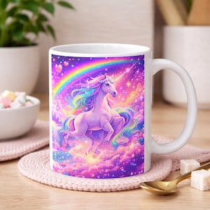May include: A white ceramic mug with a black handle and the text "But First, Coffee" in a bold, black font. The mug is set against a blurred background, suggesting a cozy setting.