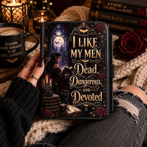 May include: A black e-reader case featuring a gothic illustration of a person reading by candlelight, with the gold text: I LIKE MY MEN Dead, Dangerous, AND Devoted. The design includes red roses, a stack of books, a black cat, and a full moon.