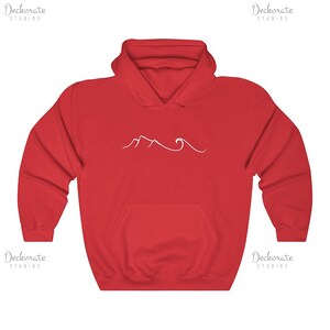 May include: A red hooded sweatshirt with a white mountain and wave design. The sweatshirt has a front pocket and a drawstring hood. The design is a simple line drawing of mountains and ocean waves.