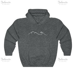 May include: A dark gray hoodie with a white mountain and wave design. The hoodie has a drawstring hood and a kangaroo pocket. The design is a simple line drawing of a mountain range and ocean waves.