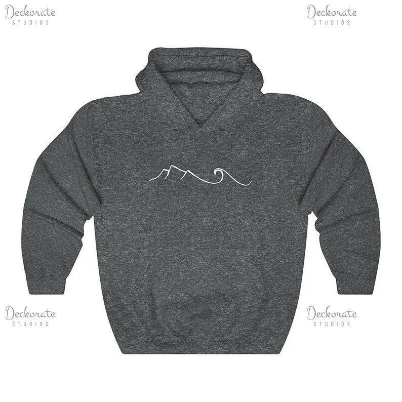 May include: A dark gray hoodie with a white mountain and wave design. The hoodie has a drawstring hood and a kangaroo pocket. The design is a simple line drawing of a mountain range and ocean waves.