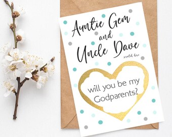 May include: A white card with blue and gray polka dots. The card says "Auntie Gem and Uncle Dave" with a gold heart that says "Will you be my Godparents?"
