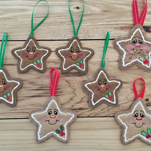 May include: Seven gingerbread star ornaments with smiling faces, red cheeks, and holly sprigs. Each ornament has a loop for hanging and is decorated with white icing.