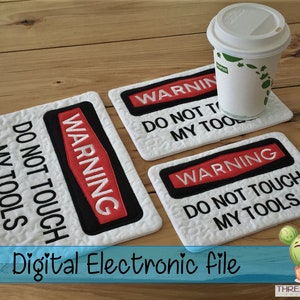 Puede incluir: Tres posavasos cuadrados blancos con texto bordado en negro y rojo que dice "WARNING DO NOT TOUCH MY TOOLS". Los posavasos están sobre una superficie de madera con una taza de café blanca.