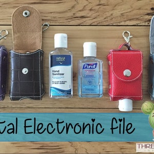 May include: Five different colored fabric pouches with snap closures and key rings. Each pouch is designed to hold a small bottle of hand sanitizer. The pouches are displayed on a wooden surface with two bottles of hand sanitizer.