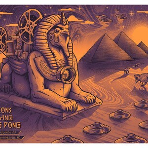 Puede incluir: Un cartel de concierto naranja y morado con una esfinge con un proyector de cine, pirámides, dinosaurios y ovnis. El texto "Pigeons Playing Ping Pong" está en la parte inferior, junto con las fechas y lugares de la gira.