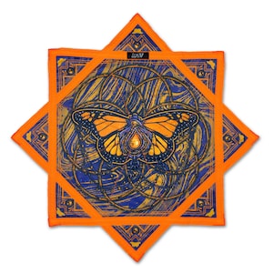 Puede incluir: Un pañuelo cuadrado naranja y azul con un diseño de mariposa monarca. La mariposa tiene alas naranjas con detalles negros sobre un fondo azul con remolinos dorados. El pañuelo está enmarcado por una estrella naranja.