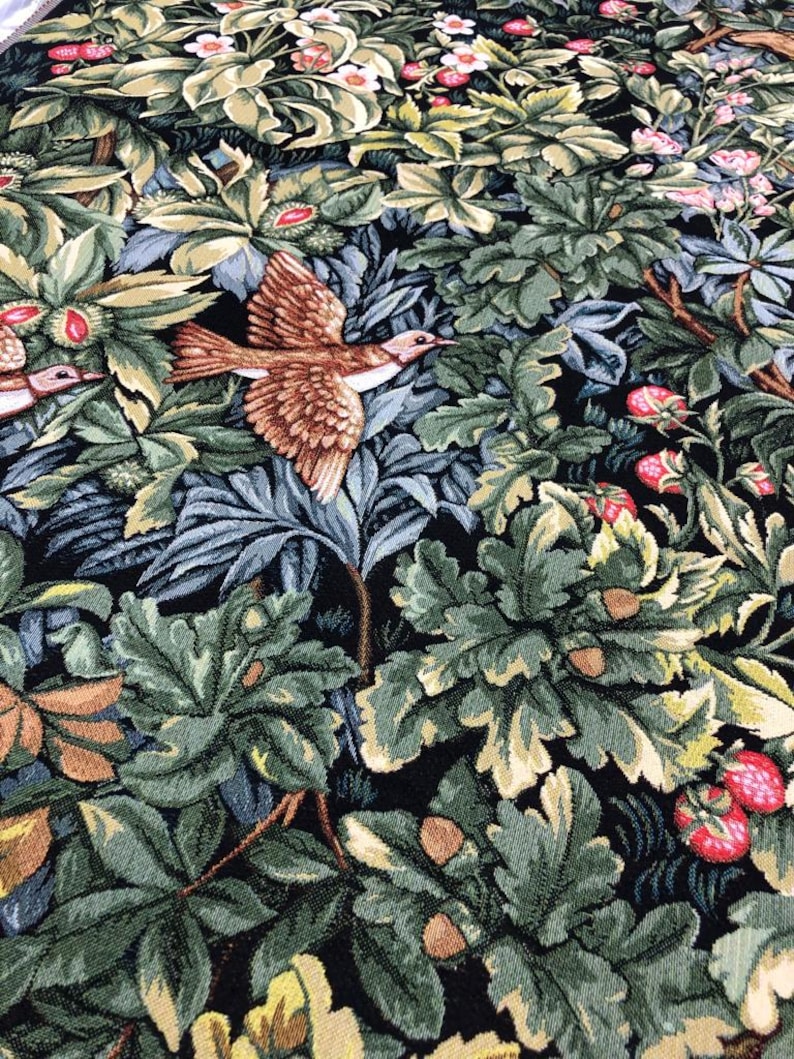 May include: A tapestry featuring a detailed design of a forest scene with birds, leaves, and berries. The tapestry is woven with a variety of colors, including green, brown, and red.