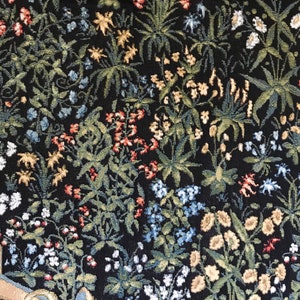 Puede incluir: Un tapiz con fondo negro y una variedad de flores de colores, incluyendo rojas, azules, amarillas y blancas. Las flores est&aacute;n dispuestas en un patr&oacute;n aleatorio y crean un dise&ntilde;o hermoso e intrincado.