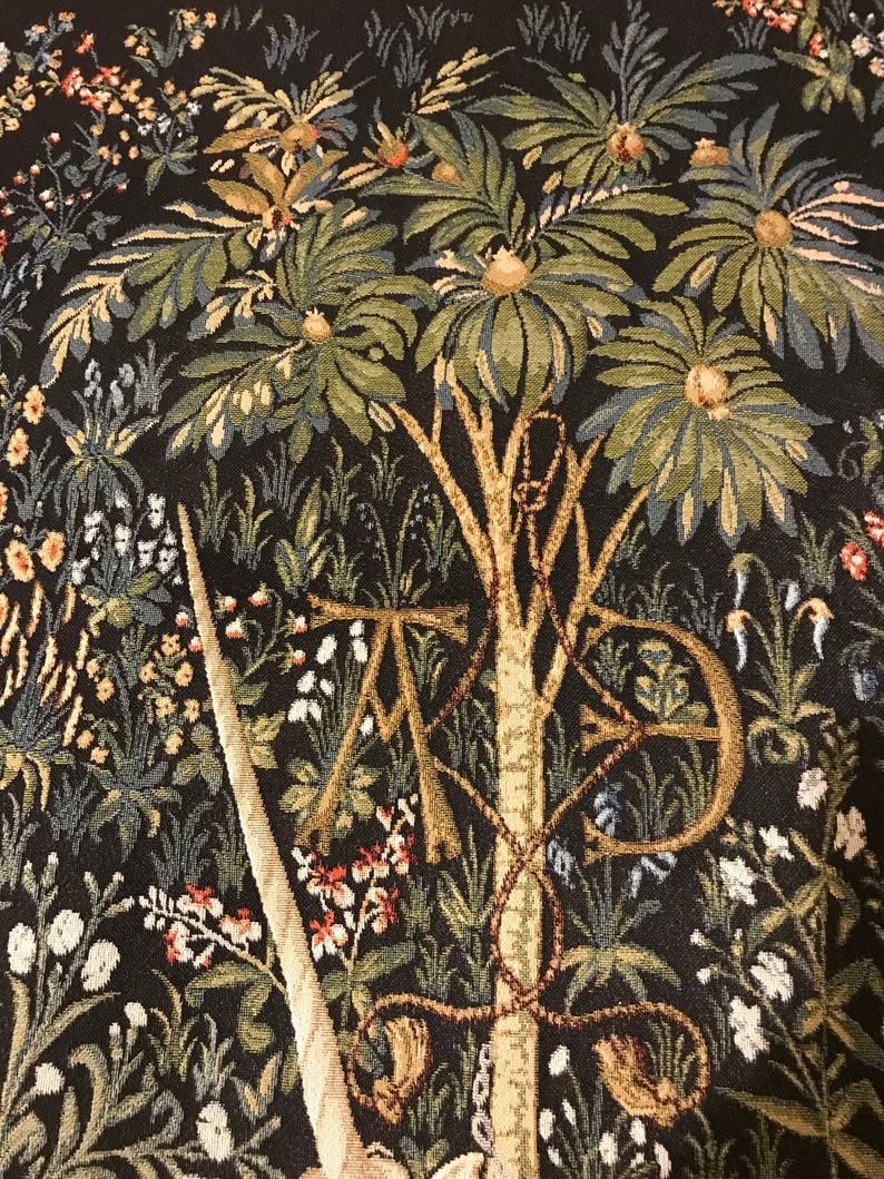 Puede incluir: Un tapiz que presenta una representaci&oacute;n detallada de un unicornio con un cuerno, rodeado de exuberante vegetaci&oacute;n y intrincados patrones florales. El tapiz est&aacute; tejido con una variedad de colores, incluyendo tonos de verde, azul y marr&oacute;n. El cuerno del unicornio es prominente y parece estar perforando una cuerda o cadena.