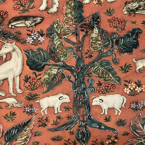 May include: A tapestry featuring a stylized tree with green leaves and a red background. The tree is surrounded by various animals, including a unicorn, a hedgehog, a rabbit, and two pigs. The tapestry is a vibrant and colorful piece of art.