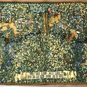 May include: A tapestry depicting a forest scene with a variety of trees, flowers, and animals. The tapestry is woven with intricate details and vibrant colors. The text on the tapestry reads: " -  Of  I  am  my  Lord  am  I  mine  mine  own  good  Lord  ever  I  shall  be  - "