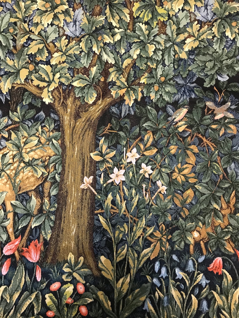 May include: A tapestry depicting a forest scene with a large tree, deer, and various flowers and plants. The tapestry features a dark blue background with shades of green, brown, and white.