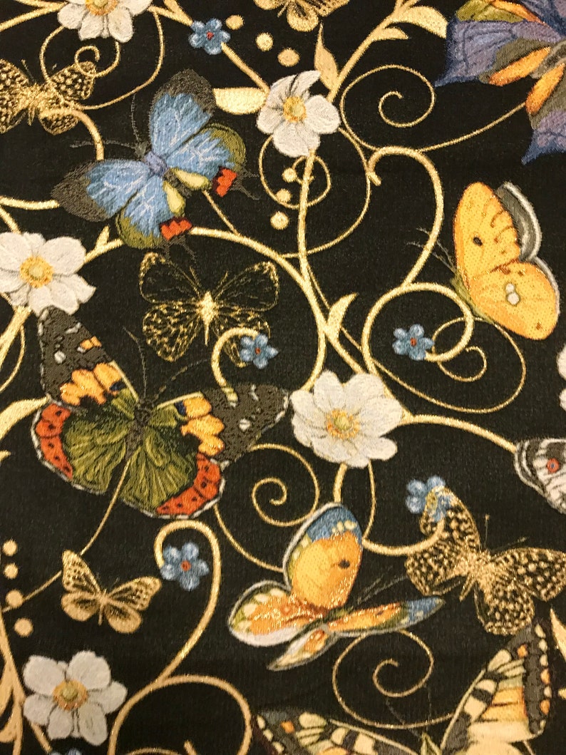 May include: Black fabric with a gold floral pattern and colorful butterflies. The butterflies are embroidered with intricate details and have a variety of colors, including blue, yellow, and green.
