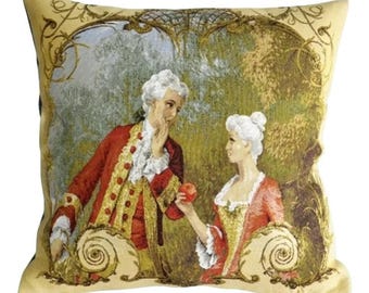May include: A tapestry pillow featuring a couple in 18th-century clothing. The man is wearing a red and gold jacket, and the woman is wearing a red and gold dress. They are standing in a garden setting with a green background.