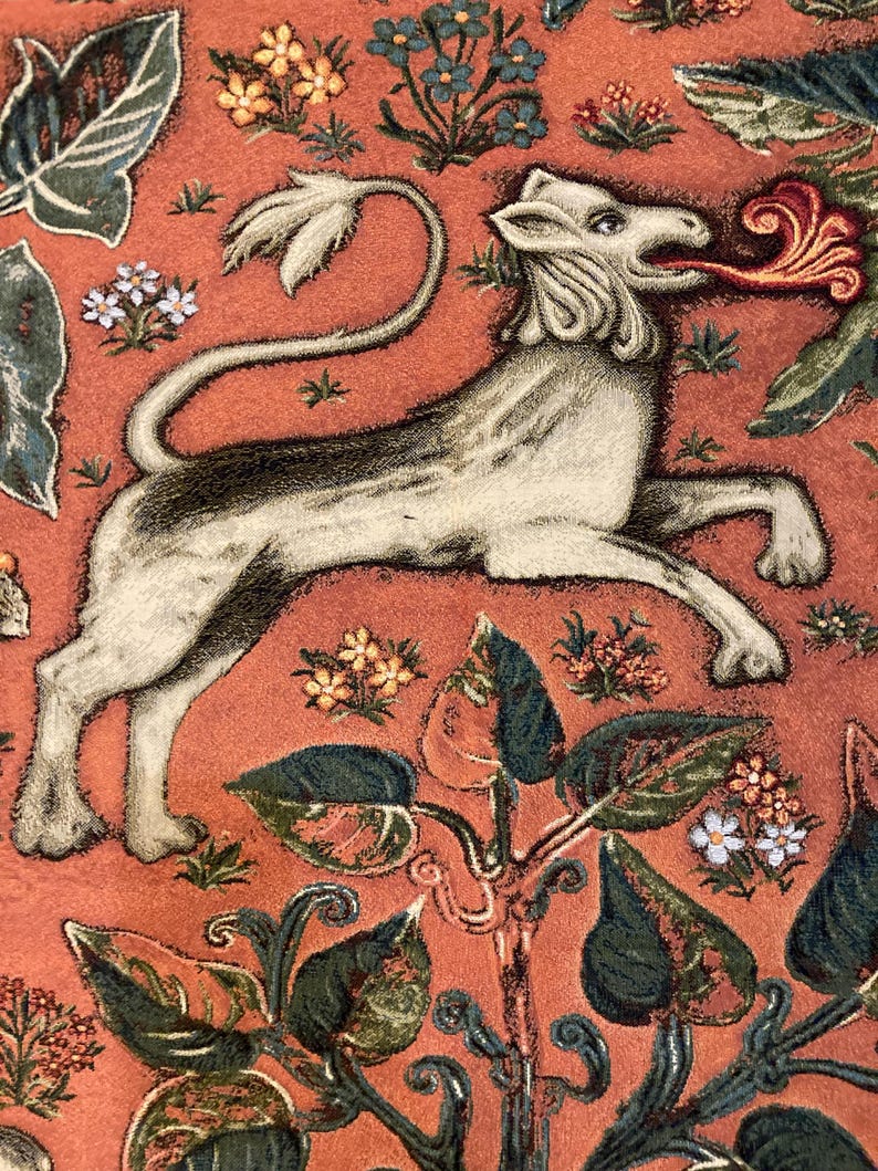 May include: A white tapestry with a stylized lion with a red flame coming out of its mouth. The lion is surrounded by green and orange floral designs.