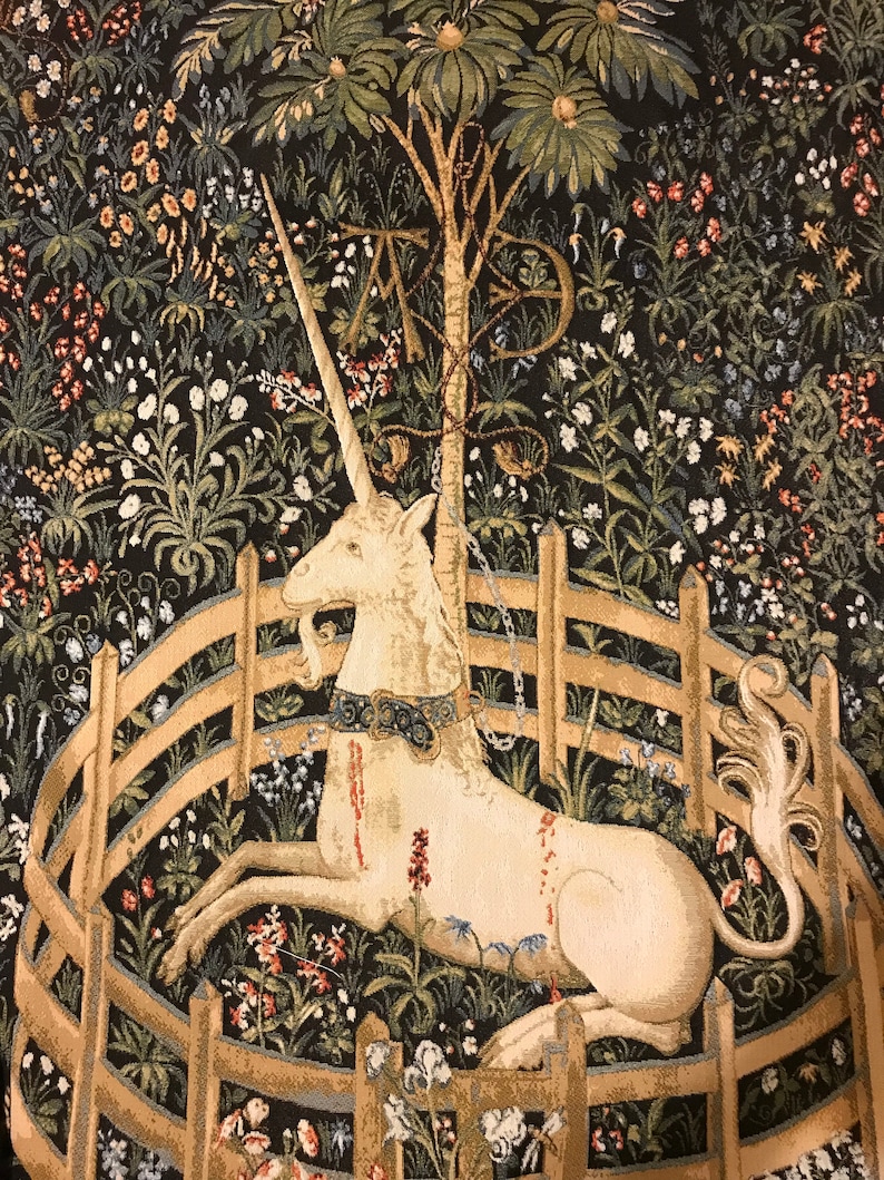 Puede incluir: Un tapiz que representa un unicornio blanco con una cadena dorada alrededor del cuello, acostado dentro de una valla circular de madera. El unicornio est&aacute; rodeado de follaje verde y marr&oacute;n y flores. El tapiz tiene un fondo oscuro.