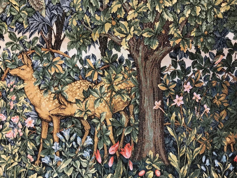 May include: Two brown deer with white spots stand in a lush green forest with pink and blue flowers. The deer are partially hidden by the foliage. A large tree trunk is visible in the background.